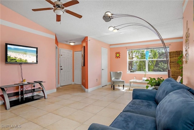 living area featuring a ceiling fan, baseboards, a textured ceiling, and light tile patterned flooring