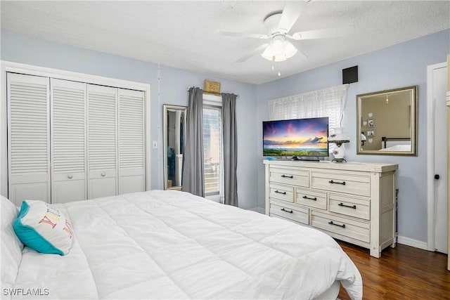 bedroom featuring a textured ceiling, dark wood-style flooring, a ceiling fan, baseboards, and a closet