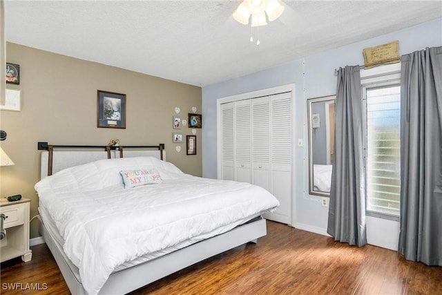 bedroom featuring dark wood-style floors, multiple windows, a closet, and a textured ceiling