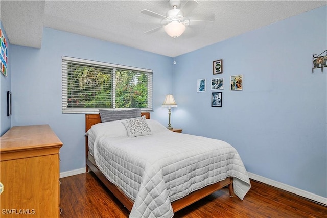 bedroom with a textured ceiling, wood finished floors, a ceiling fan, and baseboards