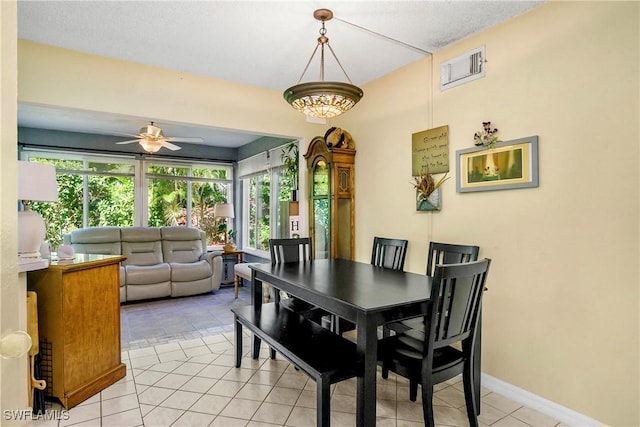 dining space with light tile patterned floors, ceiling fan, visible vents, and baseboards