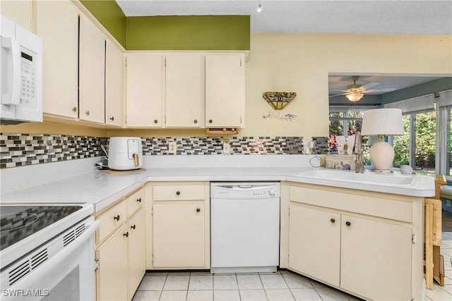 kitchen with light tile patterned floors, ceiling fan, white appliances, light countertops, and decorative backsplash