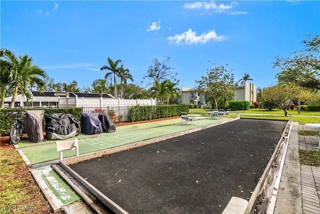 view of home's community featuring fence and shuffleboard