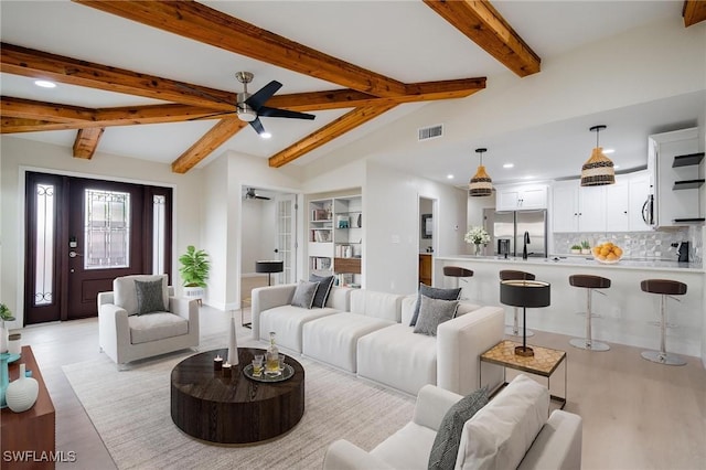 living area featuring vaulted ceiling with beams, light wood-style flooring, recessed lighting, visible vents, and a ceiling fan