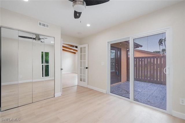 unfurnished bedroom with french doors, visible vents, ceiling fan, wood finished floors, and baseboards