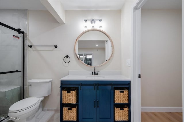 full bathroom featuring toilet, a stall shower, vanity, wood finished floors, and baseboards