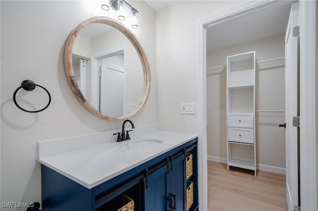 bathroom featuring vanity, baseboards, and wood finished floors