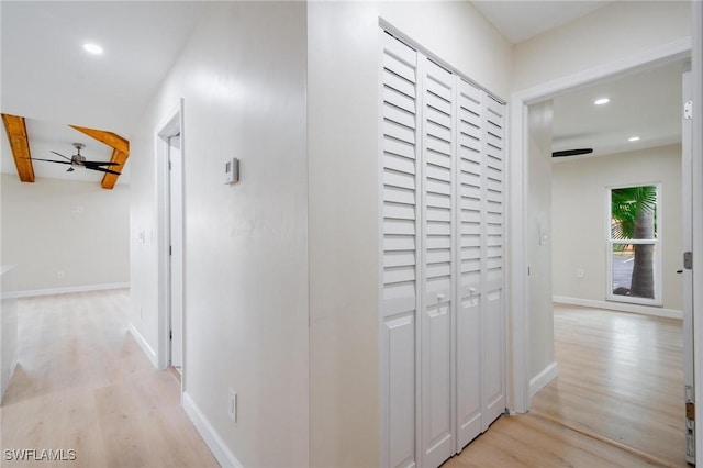 hallway with light wood-style floors, recessed lighting, beamed ceiling, and baseboards