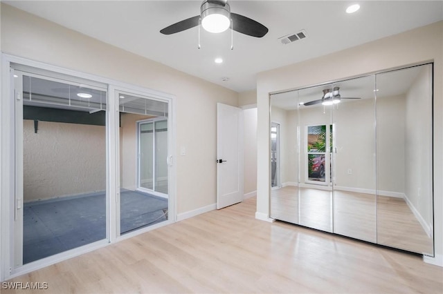 unfurnished bedroom featuring a ceiling fan, visible vents, baseboards, and wood finished floors