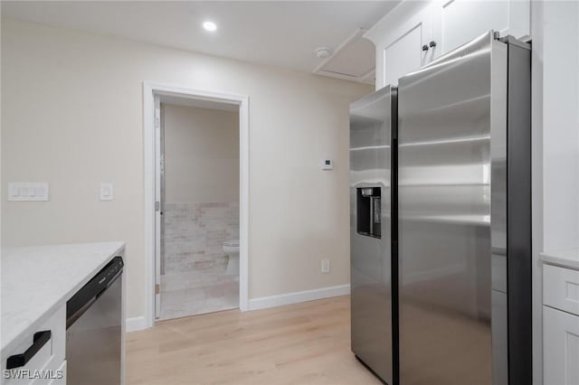 kitchen with stainless steel appliances, recessed lighting, light wood-style floors, white cabinets, and baseboards