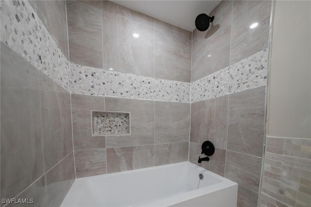 bathroom featuring a bathtub, tiled shower, and tile walls