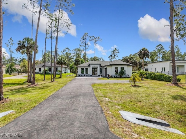 view of front of property with aphalt driveway and a front yard