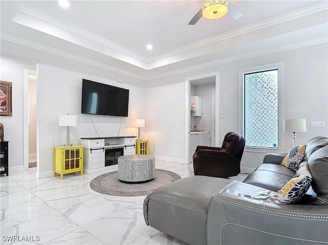 living area featuring baseboards, a raised ceiling, and marble finish floor