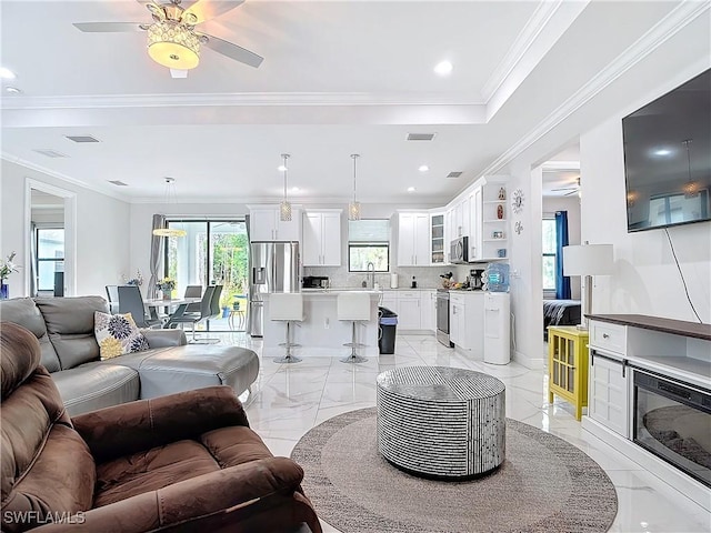 living room with visible vents, marble finish floor, a ceiling fan, and ornamental molding