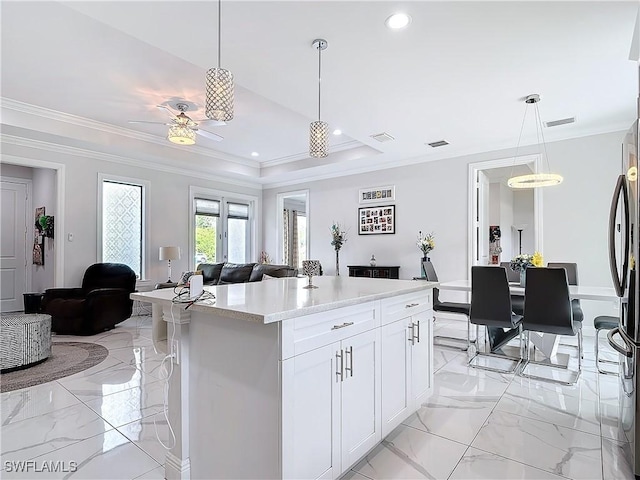 kitchen with open floor plan, marble finish floor, light countertops, and visible vents