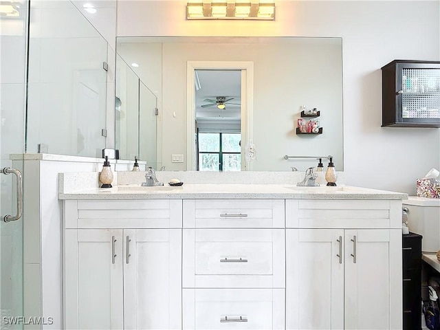 bathroom featuring a sink, a stall shower, ceiling fan, and double vanity