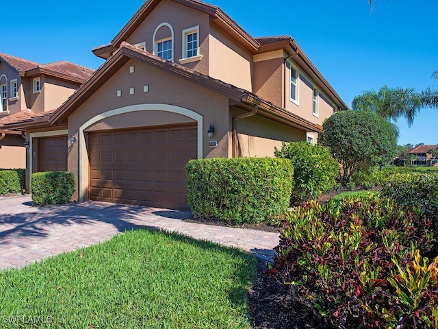 view of front of house with stucco siding and decorative driveway