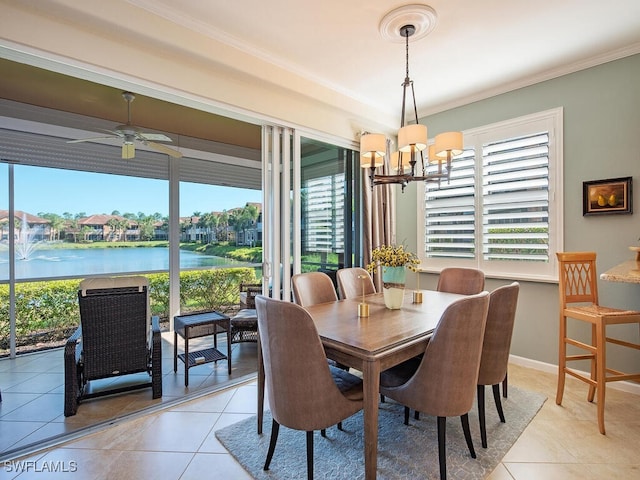 dining space with baseboards, light tile patterned flooring, a water view, crown molding, and ceiling fan with notable chandelier