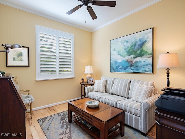 living area featuring baseboards, crown molding, ceiling fan, and wood finished floors