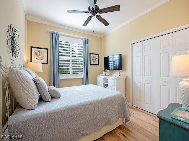 bedroom featuring a closet, light wood-type flooring, a ceiling fan, and ornamental molding