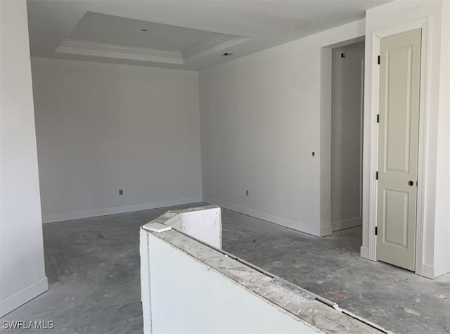 empty room with a raised ceiling and baseboards