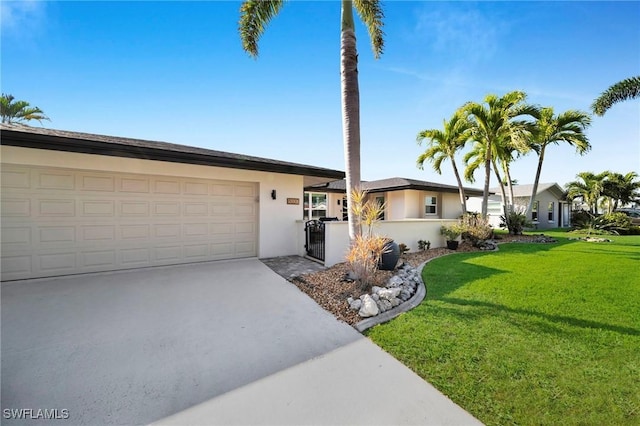 view of front of home with driveway, an attached garage, a front lawn, and stucco siding