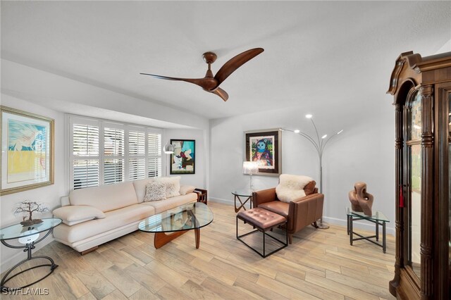 living area with light wood-type flooring, ceiling fan, and baseboards