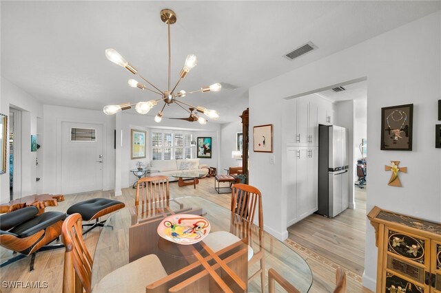 dining space featuring a chandelier, visible vents, and light wood-style flooring