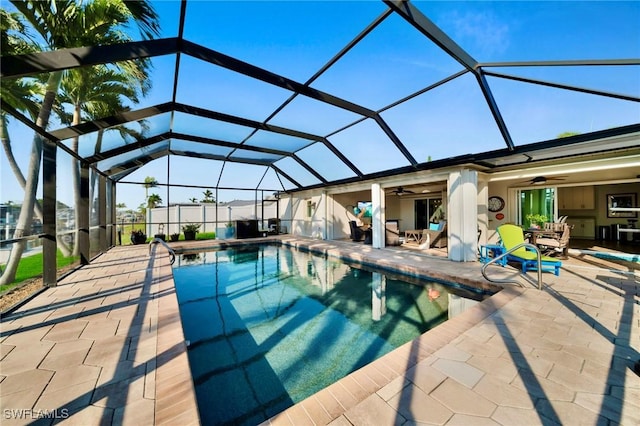 outdoor pool featuring a patio, glass enclosure, and a ceiling fan