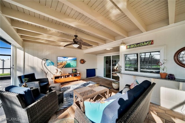 interior space featuring wood ceiling, plenty of natural light, beamed ceiling, and ceiling fan