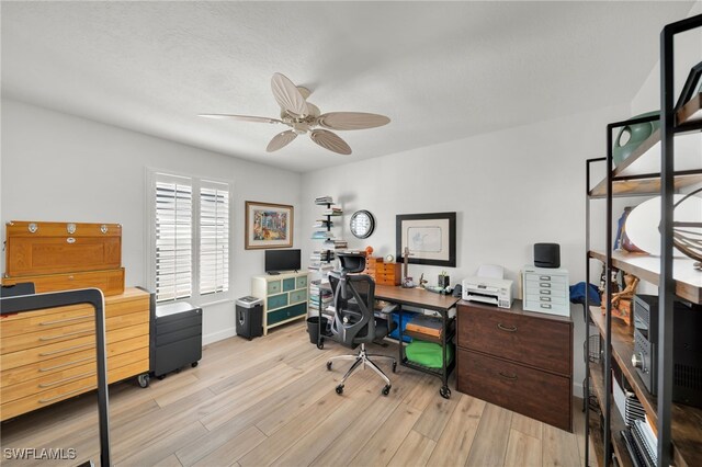 home office featuring baseboards, ceiling fan, and light wood finished floors