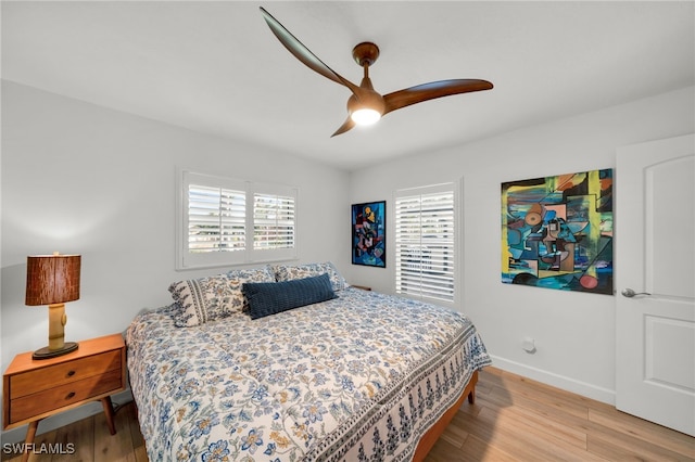 bedroom featuring light wood-style floors, baseboards, and a ceiling fan