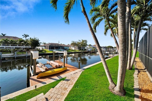 dock area with a lawn, a water view, boat lift, and a residential view