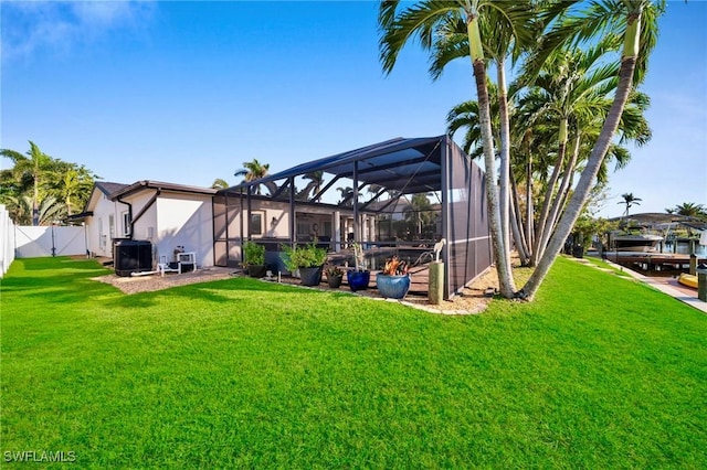 view of yard featuring central AC unit, glass enclosure, and fence