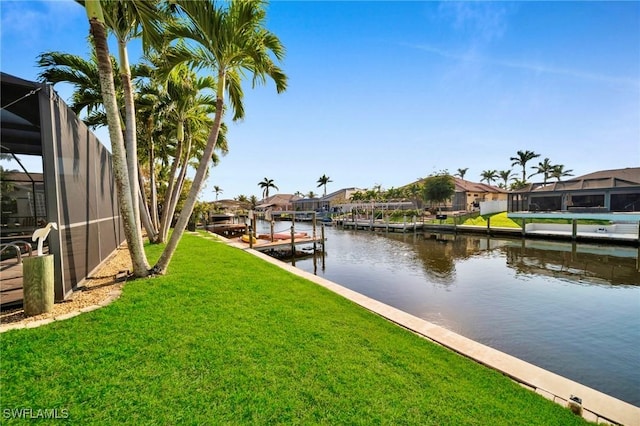 view of dock featuring a yard, a residential view, glass enclosure, and a water view