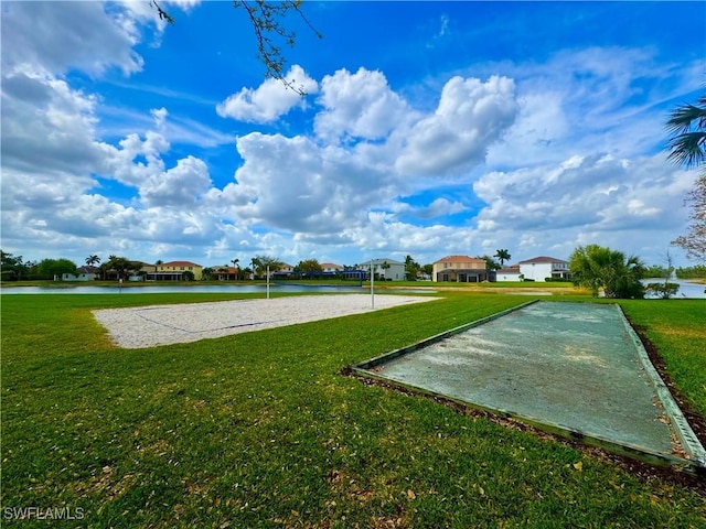 view of property's community featuring a yard, a water view, and volleyball court