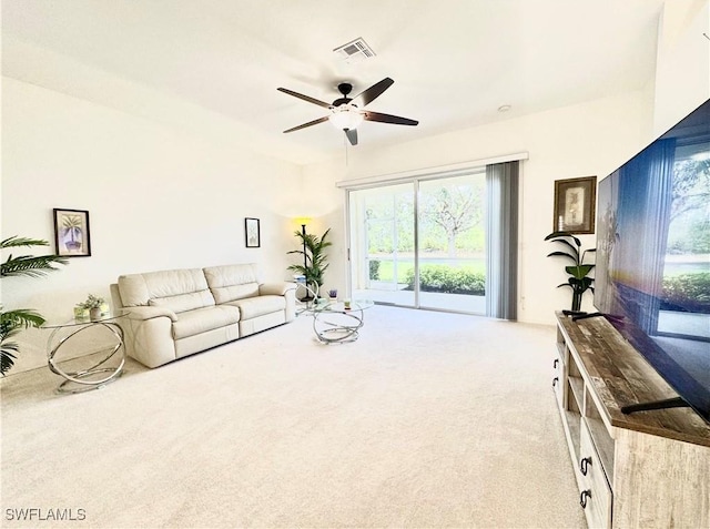 carpeted living area with visible vents and a ceiling fan