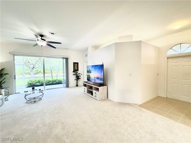 living room with a ceiling fan, visible vents, and light colored carpet