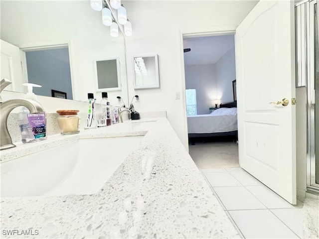 bathroom featuring double vanity, tile patterned flooring, a sink, and connected bathroom