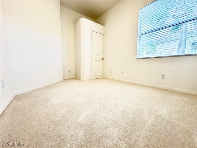 carpeted empty room with baseboards