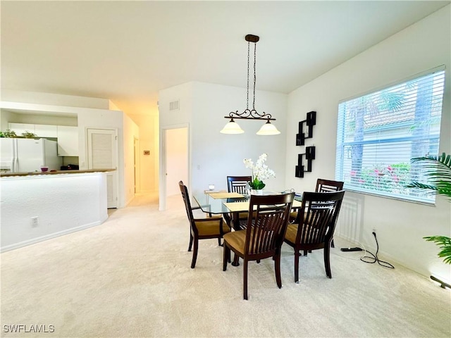 dining area with light carpet and visible vents