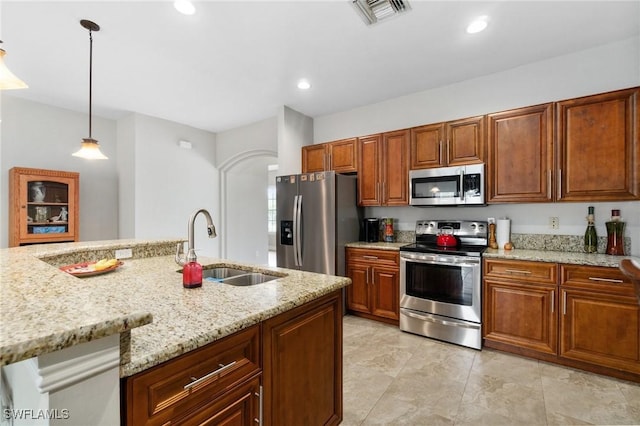 kitchen with visible vents, appliances with stainless steel finishes, hanging light fixtures, light stone countertops, and a sink