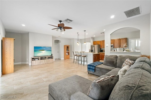 living area featuring visible vents, arched walkways, and recessed lighting