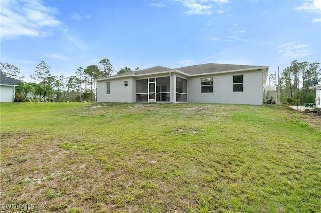 rear view of property with a sunroom and a lawn