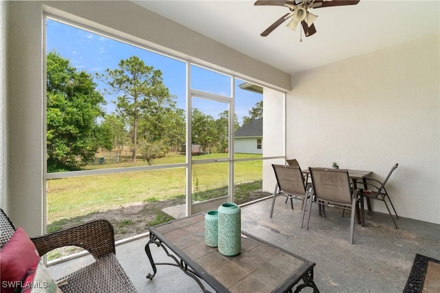 sunroom / solarium featuring ceiling fan