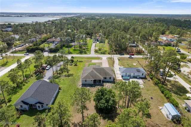 bird's eye view with a water view and a wooded view