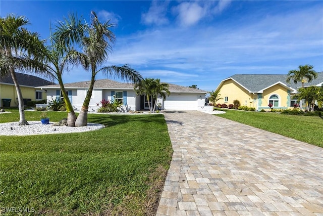 ranch-style home featuring a garage, a front lawn, and decorative driveway