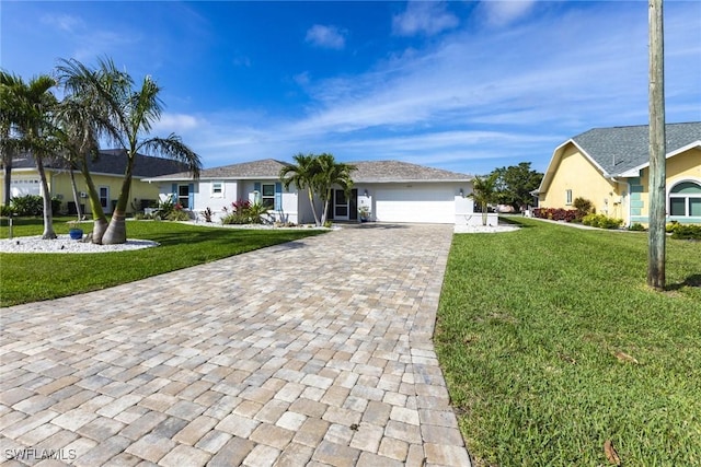 ranch-style house featuring an attached garage, decorative driveway, and a front yard