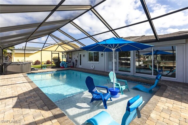 outdoor pool with glass enclosure, a patio area, and a hot tub