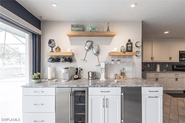 bar with a dry bar, beverage cooler, decorative backsplash, appliances with stainless steel finishes, and recessed lighting